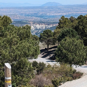 Gravel track winding down into the Gorafe Desert, offering a scenic cycling route through the rugged Spanish landscape on Hidden Tracks Cycling's Flamenco Gravel trip.