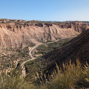 Stunning view of Val de Colores in the Gorafe Desert, showcasing the vibrant Badlands gravel bike ride during Hidden Tracks Cycling's Flamenco Gravel trip in spring.