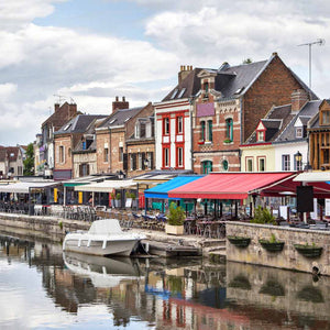 Picturesque scene of bars on the side one of the many canals in Amiens, a stop on Hidden Tracks Cycling's Gravel adventure from London to Paris.