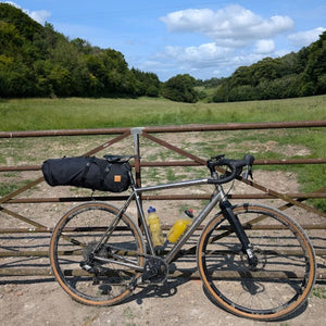 Gravel Bike leaning against a gate on a Hidden Tracks Cycling Gravel Adventure