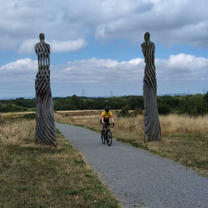 Gravel cyclist riding through Kent, past 2 decorative pillars enroute for Dover on Hidden Tracks Cycling's Trail of 2 cities gravel bike adventure from London to Paris