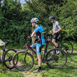 Group of gravel riders on mountain bikes taking a break in a long bike ride