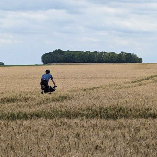 Grave cyclists riding through a field of Wheat en route to Paris on Hidden Tracks Cycling trail of 2 cities London to Paris off road adventure