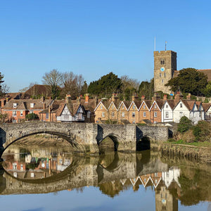 Old Aylesford bridge reflected in River Medway on a bright sunny spring day.