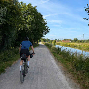 Gravel cyclist on a French Rue Verte aside a canal on Hidden Tracks Cycling Landrace to Paris bike ride.