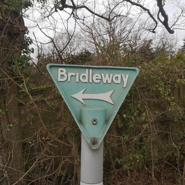Triangular green coloured bridleway sign