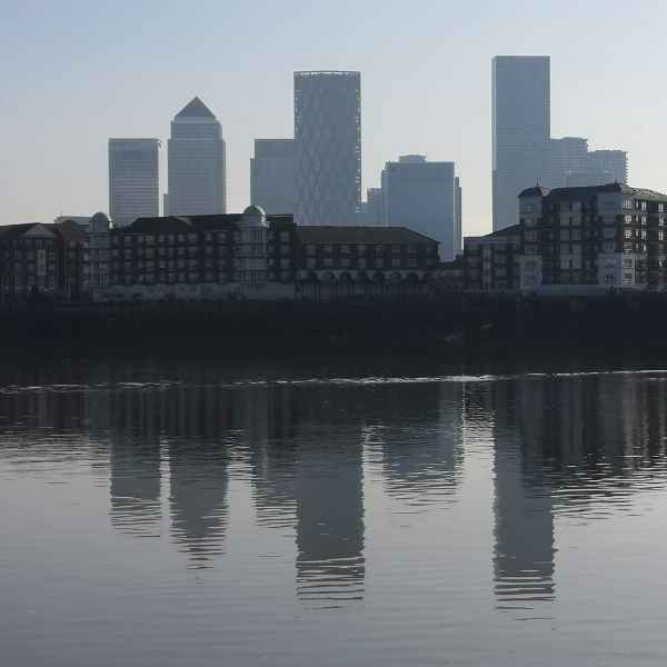 Canary Wharf reflected in the still water of the Thames at low tide from Tidal Explorer, a traffic-free  gpx bike route from Hidden Tracks Cycling