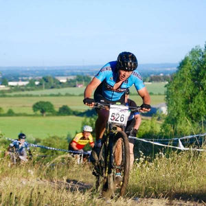 Mountain biker competing in a race on a bright sunny day 