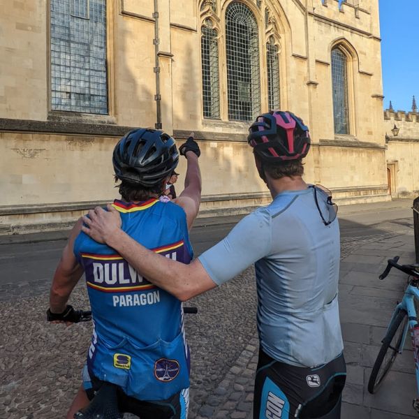 Two cyclists looking at All Souls Library in Oxford