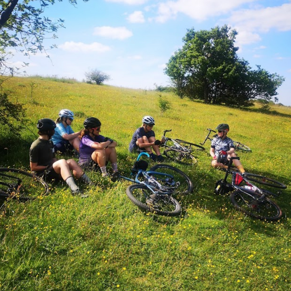 A group of female riders resting on the shade of a tree on Farthing Downs from Hidden tracks cycling 4 Commons GPX bike route