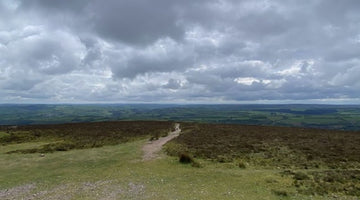 View from the top of Exmoor showing a gravel track across open moorland under heavy skies during a UK gravel ultra recce
