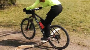 Woman cyclist practising a front wheel lift on a Hidden Tracks Bike ride 
