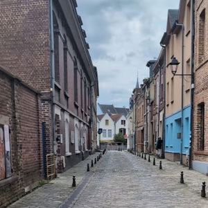 Typical street in Amiens, a cobbled street with traditional French brick houses on either side, a scene seen often on Hidden Tracks Cycling's Trail of Two Cities tour from London to Paris 