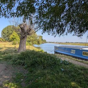 A gravel bike rider takes a break by the River Thames, enjoying the peaceful Sunday atmosphere.