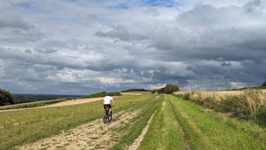 A cyclist on a mountain bike riding along a chalk path under a threatening grey sky