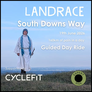 A druid in white robes standing on top of the Downs, crook in hand, promoting the Landrace Gravel series of bike rides to and from London 
