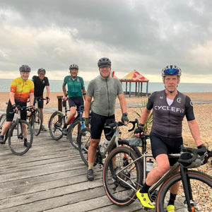 5 gravel bike riders on the boardwalk on Folkestone's shingle beach on Hidden Tracks Cycling's Landrace Gravel bike ride to Folkestone 