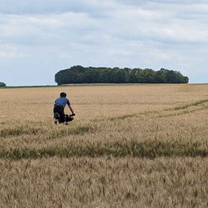 Grave cyclists riding through a field of Wheat en route to Paris on Hidden Tracks Cycling trail of 2 cities London to Paris off road adventure 