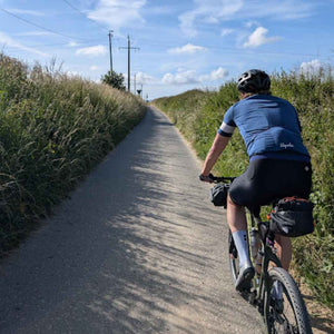 A gravel cyclist riding on a quiet lane in Picardy on Hidden Tracks Cycling's Trail of Two Cities, an off road ride between London and Paris 