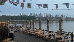 Empty riverside benches with bunting overhead and the city skyline across the Thames during the 360 Gravel event.