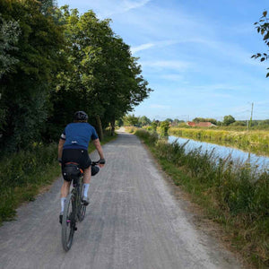 Gravel cyclist on a French Rue Verte aside a canal on Hidden Tracks Cycling Landrace to Paris bike ride.  