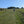 Load image into Gallery viewer, Cyclist riding a grass double-track through a sheep pasture on the South Downs, on the Brighton Bound route.
