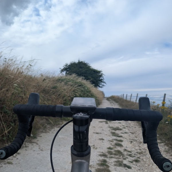 Handlebar view along a chalky gravel track on the South Downs section of the Brighton Bound route.