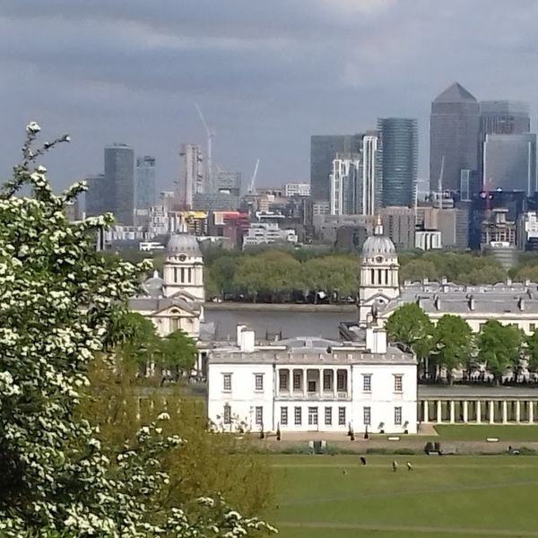 Old Royal Naval College towers in Greenwich with the Canary Wharf skyline behind, a highlight of this London bike ride