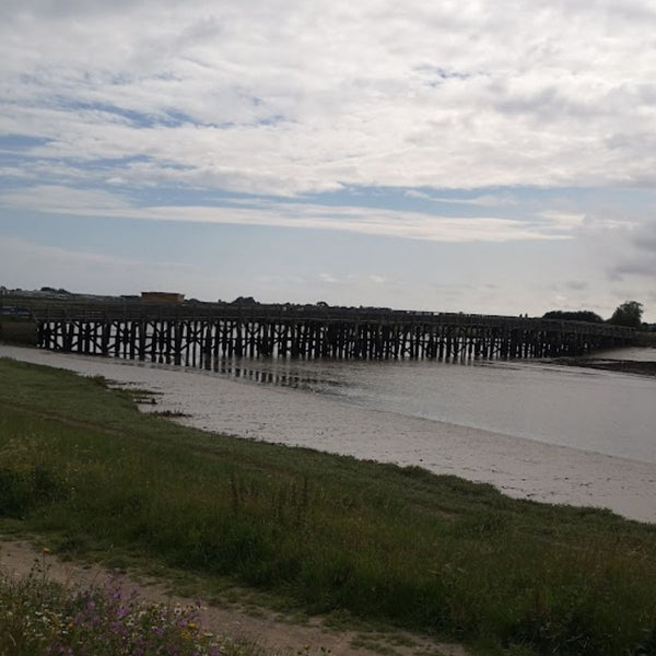 Long wooden pier crossing a tidal estuary on the No Hills to Brighton route, near Shoreham.
