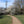 Load image into Gallery viewer, A cyclist follows a gravel path past blackthorn blossom and a mobile mast in Queen Mary's Park on the Ophelia in the Hogs Mill route.
