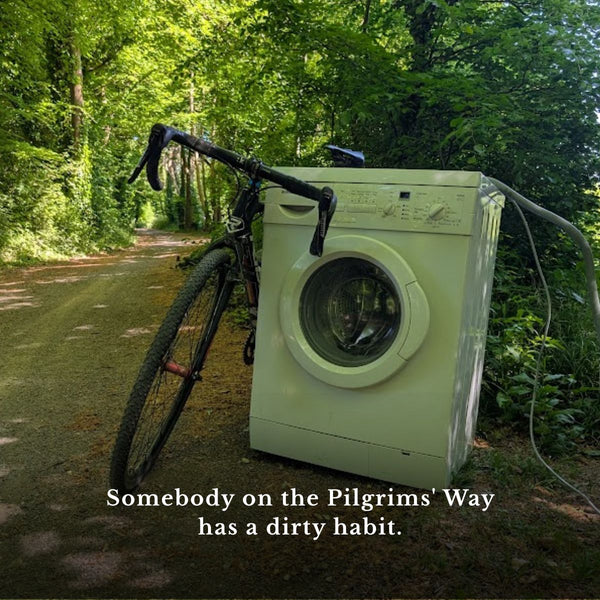 A gravel bike leaning against an old washing machine dumped on the Pilgrims' Way, on The Runaway King gravel route to Faversham.