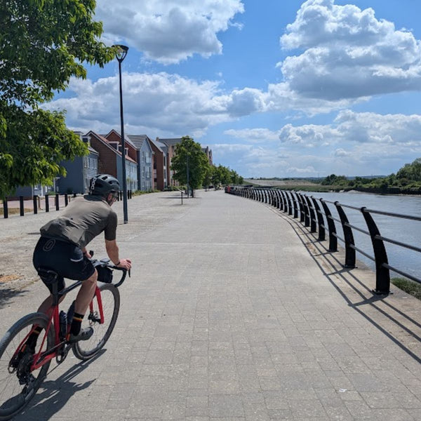 Cyclist on the riverside path along the River Medway at Peters Village, on The Runaway King gravel route from London to Faversham.
